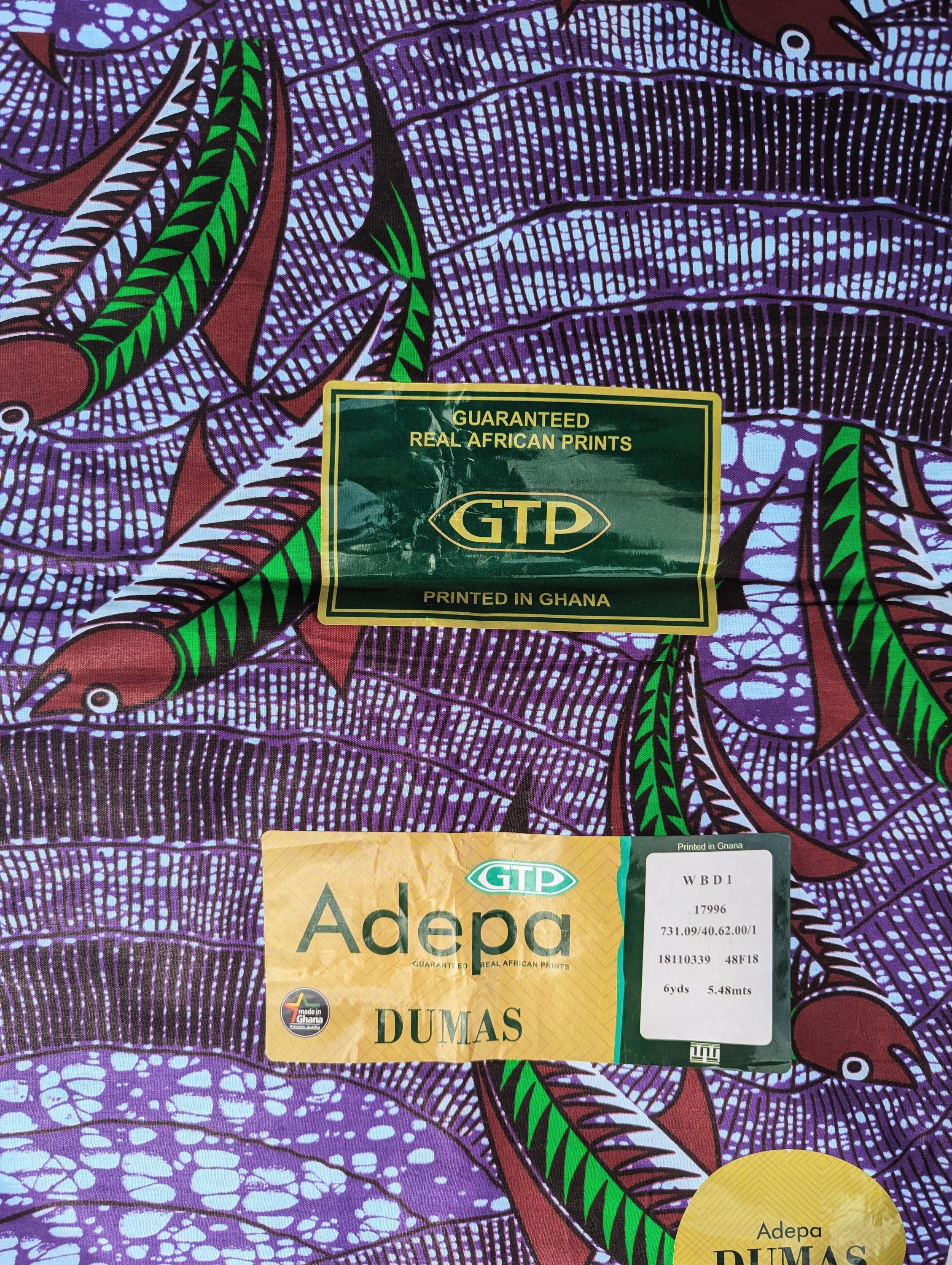 Vibrant African wax print fabric featuring a dynamic underwater scene of green and red fish swimming through wavy purple and blue waters. The background has a textured pattern resembling flowing currents and bubbles, adding movement and depth to the design. Perfect for bold fashion or aquatic-themed crafts. The fabric is made in Ghana by GTP (Ghana Textile Production)