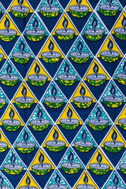 Bold African wax print fabric featuring a repeating pattern of green and yellow candle bowls with blue flames, set inside alternating teal and yellow triangles on a dark blue background.