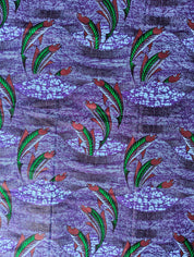 Vibrant African wax print fabric featuring a dynamic underwater scene of green and red fish swimming through wavy purple and blue waters. The background has a textured pattern resembling flowing currents and bubbles, adding movement and depth to the design. Perfect for bold fashion or aquatic-themed crafts.