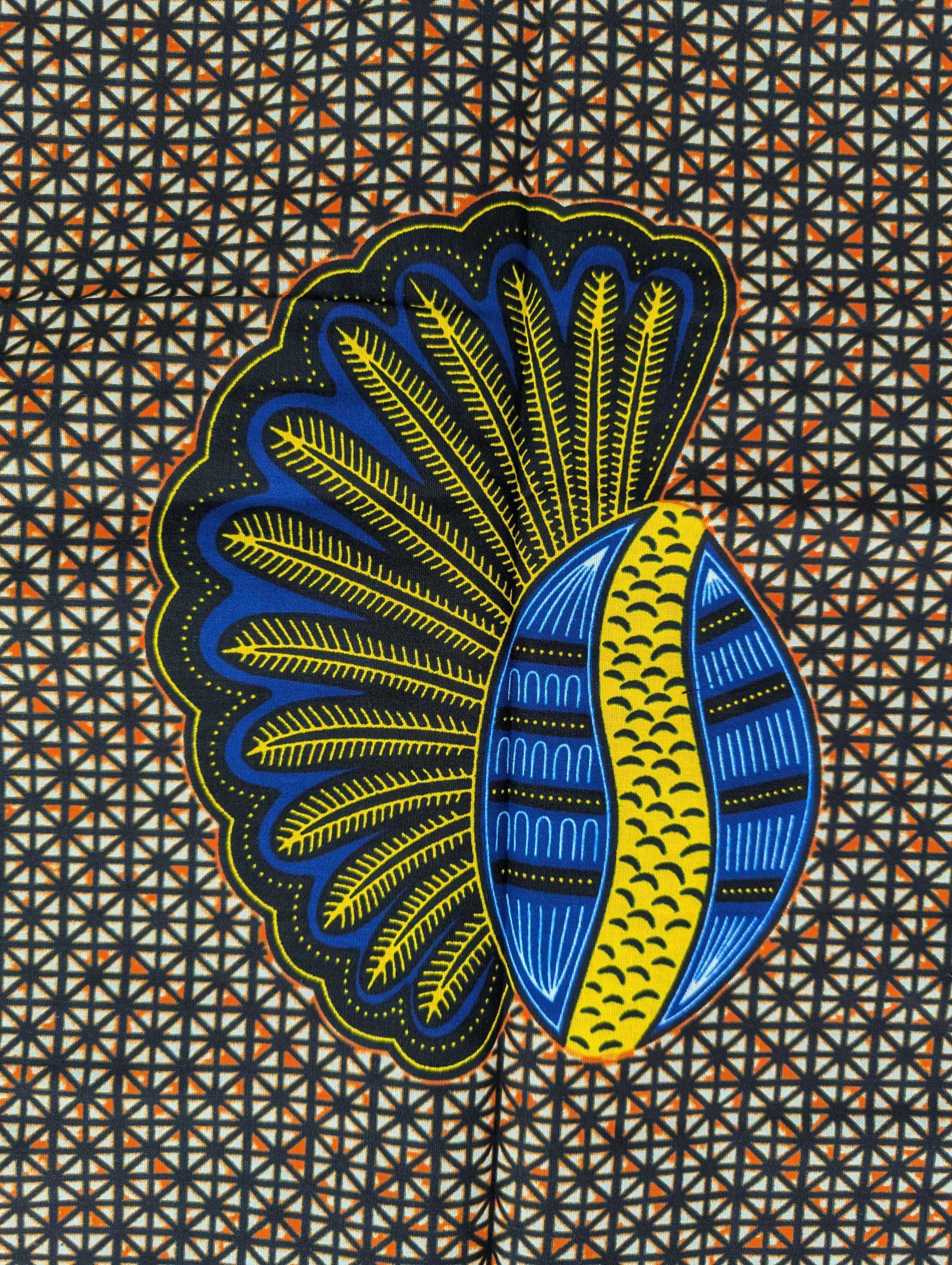 African wax print fabric featuring a repeating pattern of bold banana seed motifs in blue, yellow, and black. Each seed design has a fan-like shape on one side and a curved oval on the other, set against a detailed geometric background of small cream and brown triangles. The vibrant colours and symmetrical layout make this fabric ideal for striking garments or accessories.