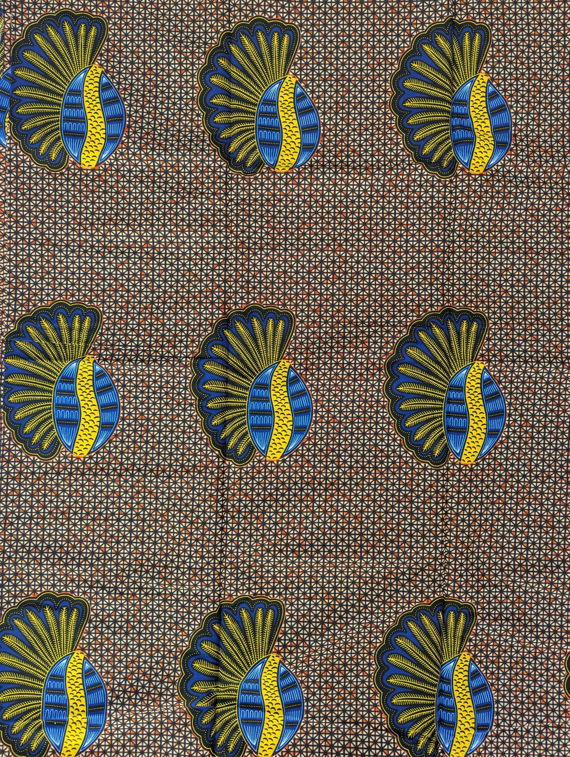 African wax print fabric featuring a repeating pattern of bold banana seed motifs in blue, yellow, and black. Each seed design has a fan-like shape on one side and a curved oval on the other, set against a detailed geometric background of small cream and brown triangles. The vibrant colours and symmetrical layout make this fabric ideal for striking garments or accessories.