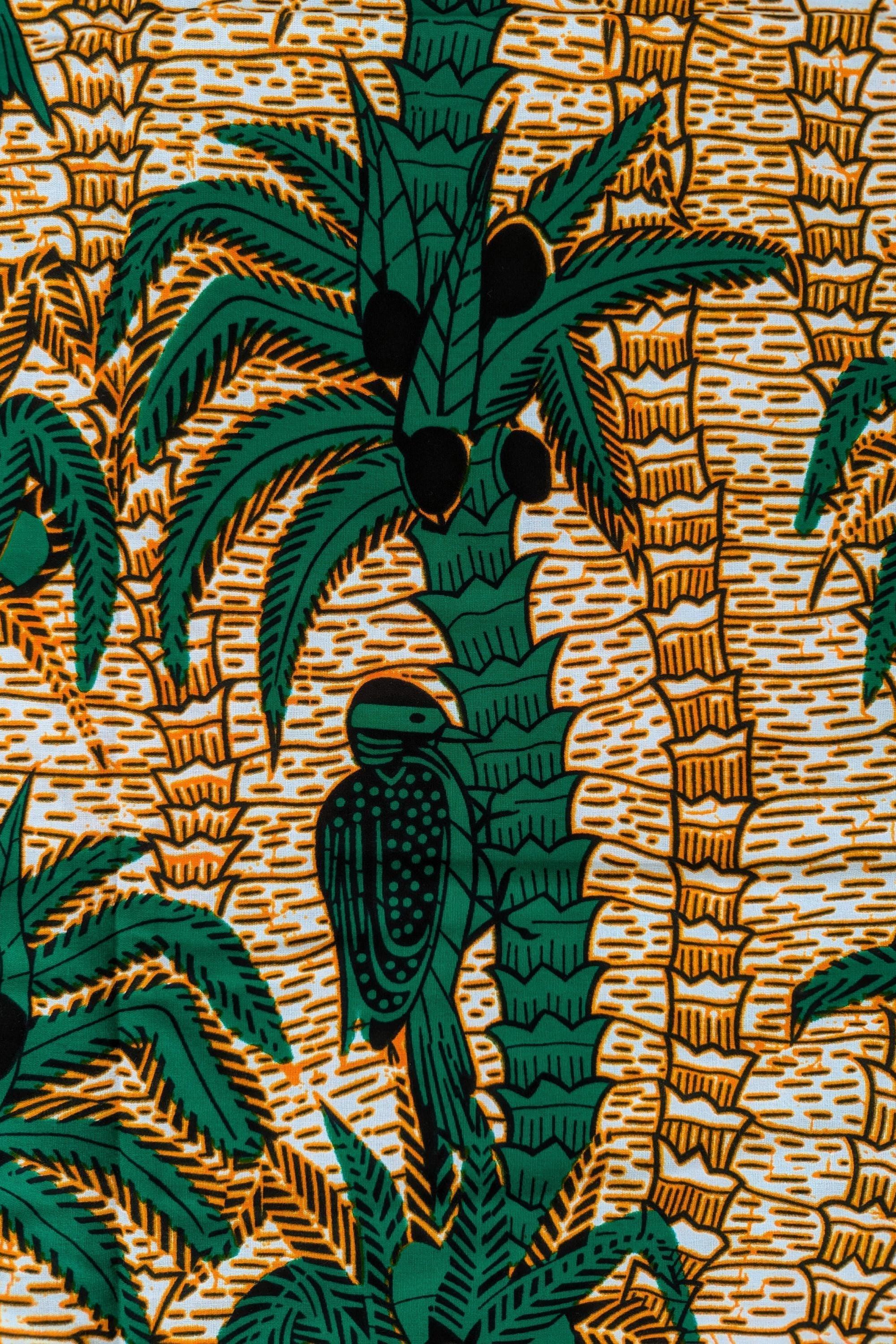 Tropical-themed African wax print fabric featuring green palm trees with coconuts and perched birds, set against a warm background of textured golden-brown lines. The repeating pattern creates a lush, jungle-like feel, perfect for vibrant fashion, home decor, or craft projects.