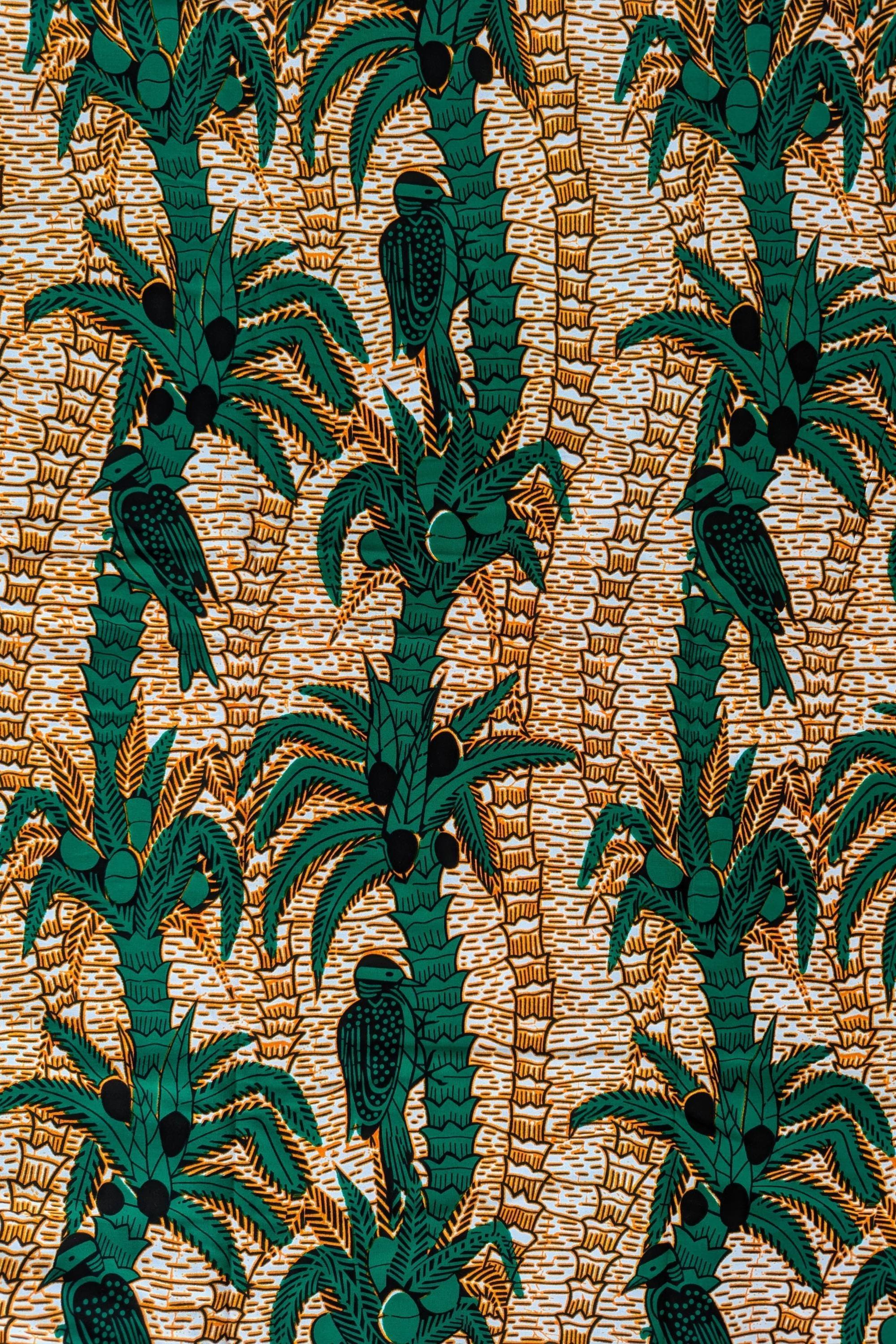 Tropical-themed African wax print fabric featuring green palm trees with coconuts and perched birds, set against a warm background of textured golden-brown lines. The repeating pattern creates a lush, jungle-like feel, perfect for vibrant fashion, home decor, or craft projects.